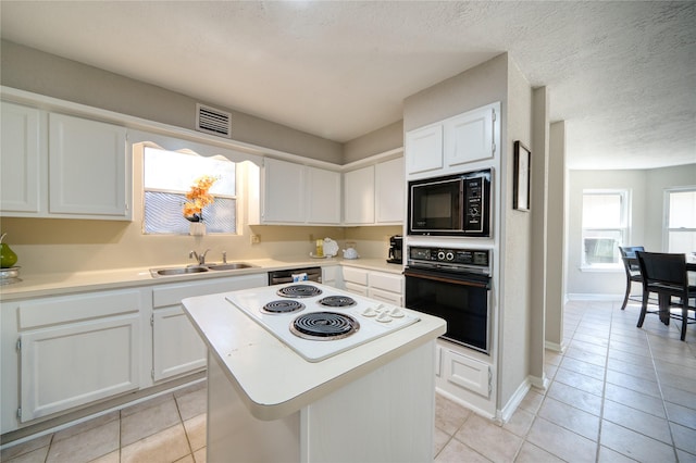 21434 Park Bluff Dr, Katy, TX 77450 - kitchen with black appliances, light tile patterned flooring, white cabinets, light countertops, and a textured ceiling