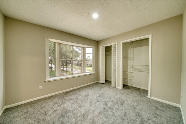 21434 Park Bluff Dr, Katy, TX 77450 - unfurnished bedroom featuring multiple closets, carpet floors, and a textured ceiling
