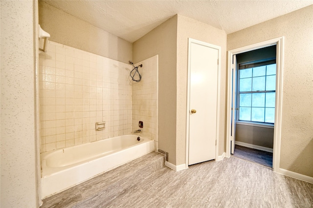 21434 Park Bluff Dr, Katy, TX 77450 - bathroom with wood finished floors, shower / bathtub combination, and a textured ceiling