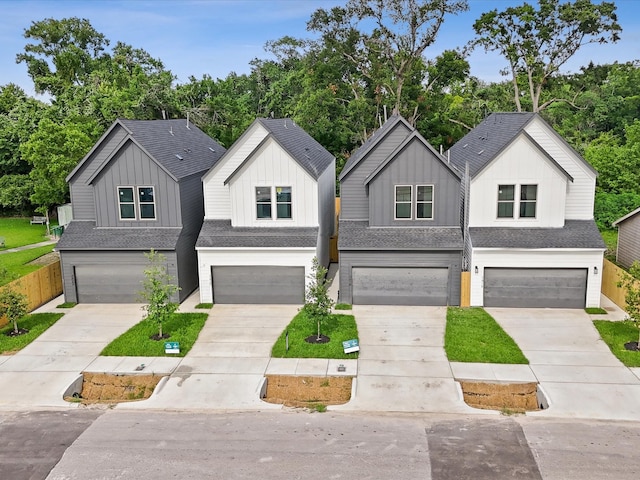 7420 Maxroy St, Houston, TX 77088 - view of front of house featuring a garage, board and batten siding, and concrete driveway