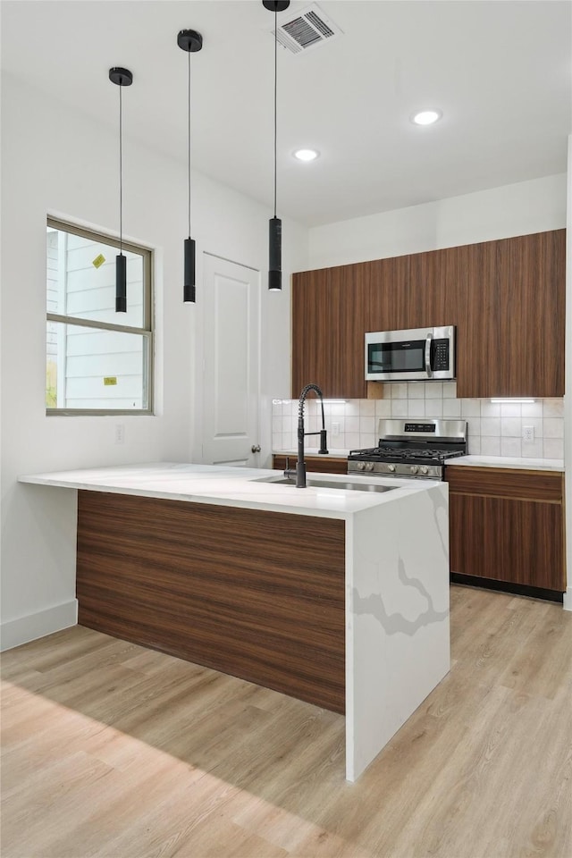 7420 Maxroy St, Houston, TX 77088 - kitchen featuring appliances with stainless steel finishes, modern cabinets, light countertops, light wood-style floors, and recessed lighting