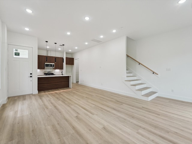 7420 Maxroy St, Houston, TX 77088 - unfurnished living room featuring light wood-style floors, recessed lighting, and stairs