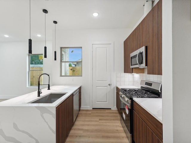 7420 Maxroy St, Houston, TX 77088 - kitchen with stainless steel appliances, modern cabinets, light wood-style floors, a peninsula, and backsplash