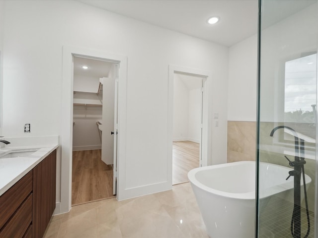 7420 Maxroy St, Houston, TX 77088 - bathroom with a freestanding bath, double vanity, a walk in closet, and recessed lighting