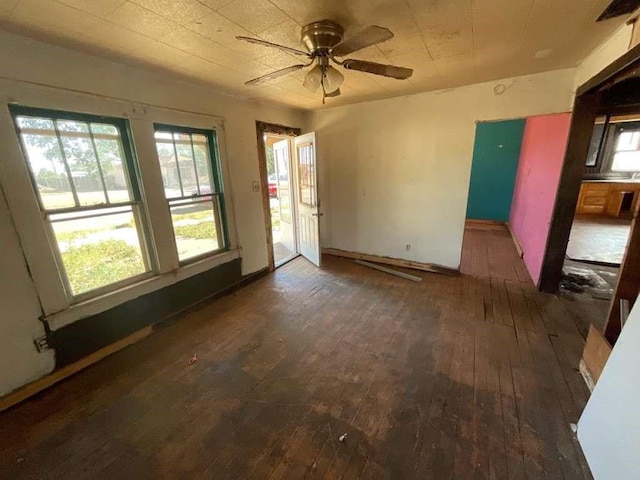 115 E Hallie St, Floydada, TX 79235 - unfurnished room featuring dark wood finished floors, plenty of natural light, and a ceiling fan