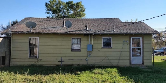 115 E Hallie St, Floydada, TX 79235 - back of property featuring a shingled roof and a lawn