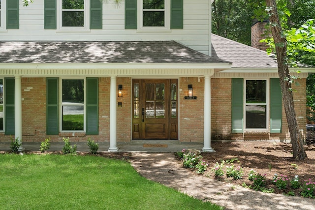 10813 Colony Wood Pl, The Woodlands, TX 77380 - entrance to property featuring roof with shingles, brick siding, a porch, and a lawn