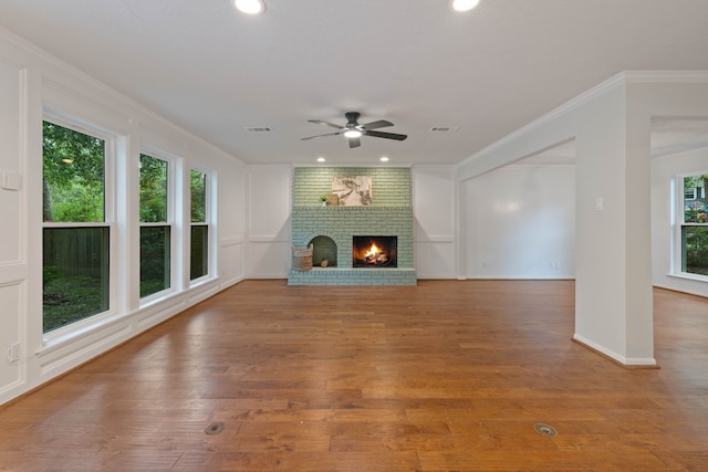 10813 Colony Wood Pl, The Woodlands, TX 77380 - unfurnished living room featuring crown molding, a ceiling fan, wood finished floors, a brick fireplace, and recessed lighting