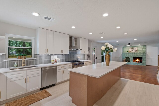 10813 Colony Wood Pl, The Woodlands, TX 77380 - kitchen featuring stainless steel appliances, wall chimney exhaust hood, plenty of natural light, a center island, and recessed lighting