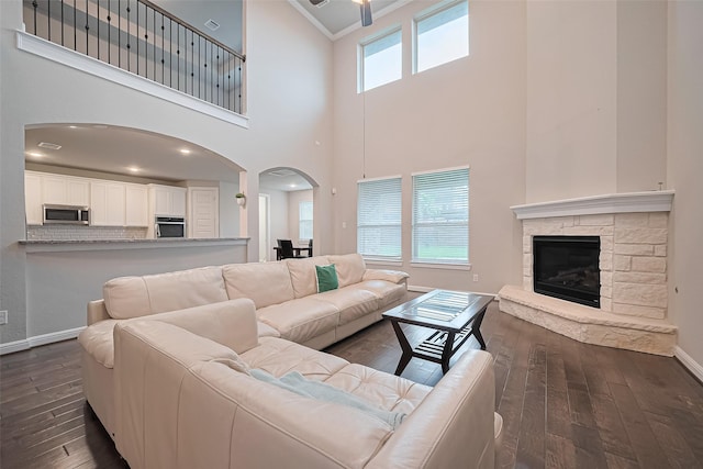11810 White Flint Ln, Cypress, TX 77433 - living area featuring a high ceiling, arched walkways, dark wood-style floors, ornamental molding, and a fireplace