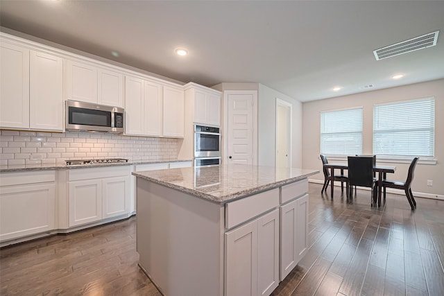11810 White Flint Ln, Cypress, TX 77433 - kitchen featuring appliances with stainless steel finishes, dark wood-style flooring, white cabinets, backsplash, and a kitchen island