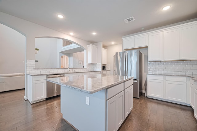 11810 White Flint Ln, Cypress, TX 77433 - kitchen with appliances with stainless steel finishes, dark wood-type flooring, white cabinetry, a kitchen island, and recessed lighting