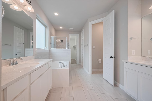 11810 White Flint Ln, Cypress, TX 77433 - full bath with a shower stall, two vanities, a garden tub, and recessed lighting