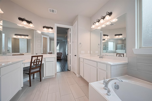 11810 White Flint Ln, Cypress, TX 77433 - bathroom with two vanities, a bath, ensuite bath, and healthy amount of natural light
