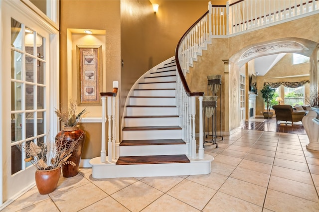 7914 Chianti Ct, Sugar Land, TX 77479 - stairs with arched walkways, tile patterned flooring, and high vaulted ceiling