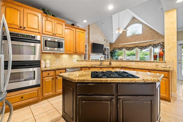 7914 Chianti Ct, Sugar Land, TX 77479 - kitchen with stainless steel appliances, light tile patterned floors, a kitchen island, tasteful backsplash, and light stone counters