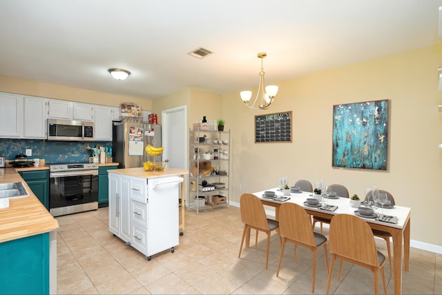 735 Red Rock Canyon Dr, Katy, TX 77450 - kitchen featuring appliances with stainless steel finishes, butcher block counters, a chandelier, tasteful backsplash, and white cabinets