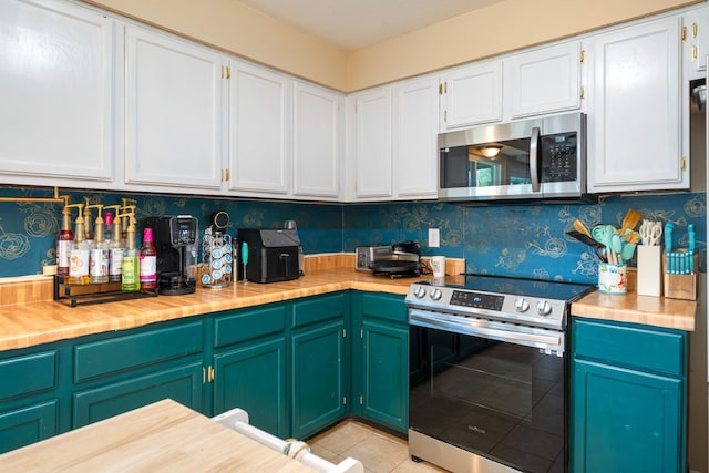 735 Red Rock Canyon Dr, Katy, TX 77450 - kitchen with appliances with stainless steel finishes, white cabinetry, light tile patterned flooring, wallpapered walls, and wooden counters