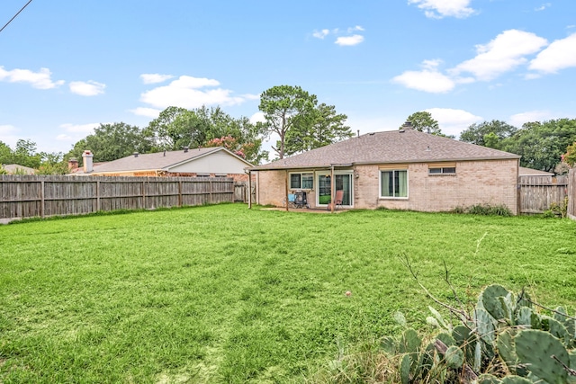 735 Red Rock Canyon Dr, Katy, TX 77450 - back of house with a fenced backyard, brick siding, and a shingled roof