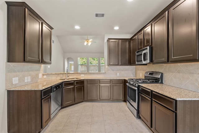6439 Wilshire Rdg, Houston, TX 77040 - kitchen with appliances with stainless steel finishes, a ceiling fan, dark brown cabinets, arched walkways, and light stone countertops
