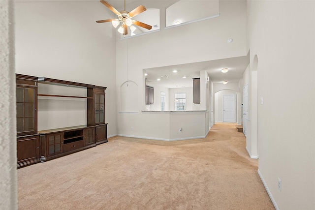 6439 Wilshire Rdg, Houston, TX 77040 - unfurnished living room with arched walkways, carpet flooring, ceiling fan, a towering ceiling, and recessed lighting