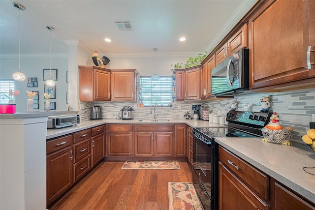 8705 W 1st St, Needville, TX 77461 - kitchen with stainless steel microwave, electric range, wood finished floors, tasteful backsplash, and light countertops