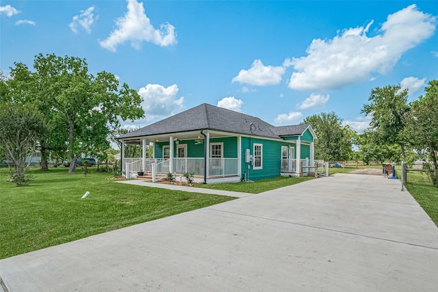 8705 W 1st St, Needville, TX 77461 - view of front of house featuring covered porch, driveway, a front lawn, and a shingled roof