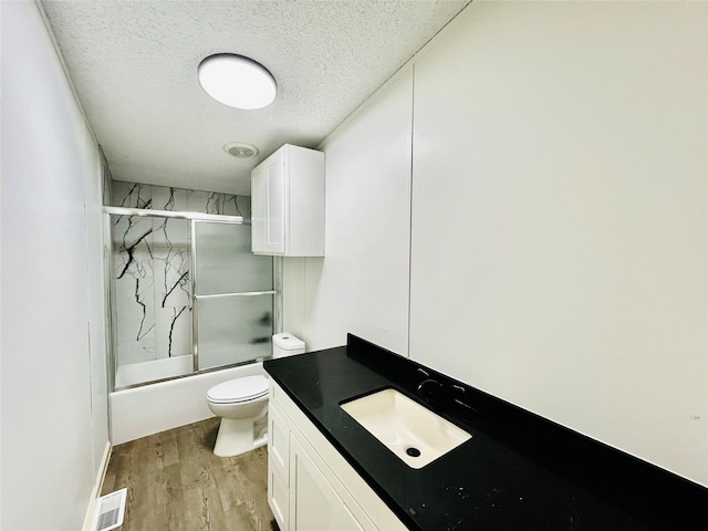 17909 Pine St Unit A, Crosby, TX 77532 - full bathroom with wood finished floors, vanity, shower / bath combination with glass door, and a textured ceiling