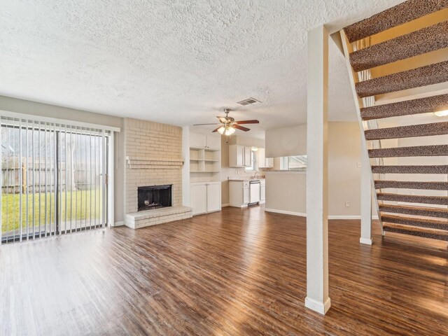 4901 Ripple Creek Dr, Baytown, TX 77521 - unfurnished living room featuring dark wood-style flooring, healthy amount of natural light, a ceiling fan, and a textured ceiling