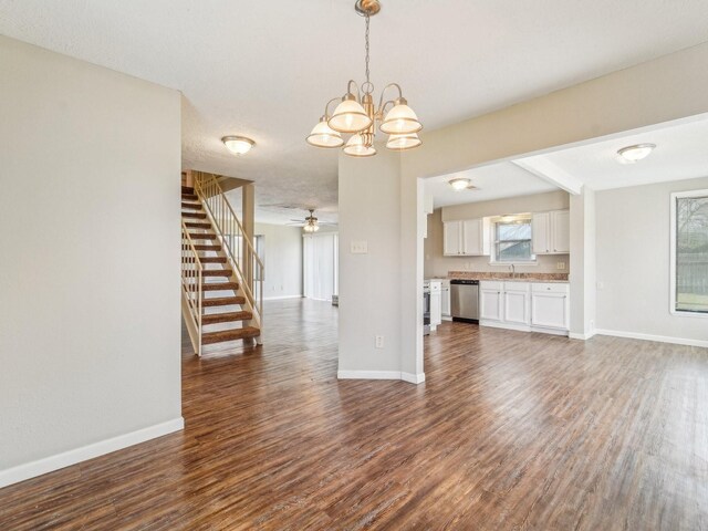 4901 Ripple Creek Dr, Baytown, TX 77521 - unfurnished living room with dark wood-style floors, stairs, a ceiling fan, and a chandelier