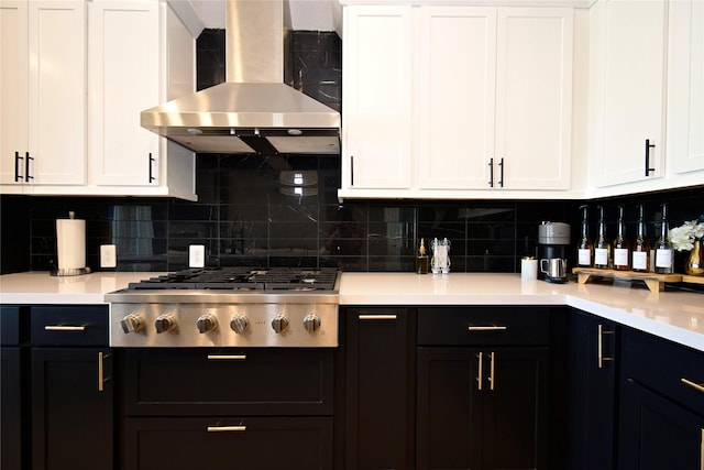 18923 Toscana Ln, New Caney, TX 77357 - kitchen featuring wall chimney range hood, stainless steel gas stovetop, tasteful backsplash, and light countertops