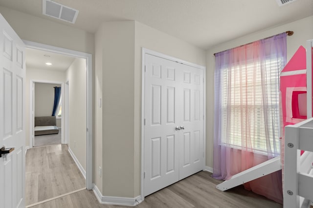 10433 Russell Pines Dr, Rosharon, TX 77583 - bedroom with light wood-style flooring, a closet, and multiple windows