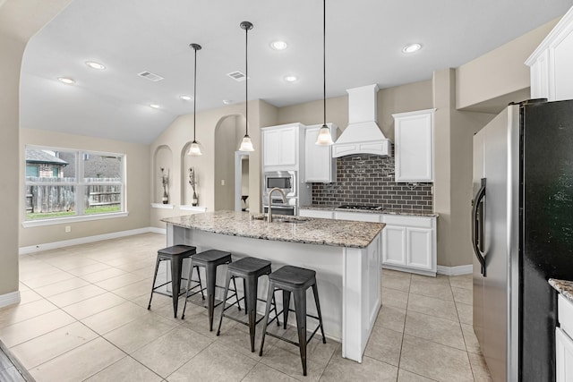 5622 Chipstone Trail Ln, Katy, TX 77493 - kitchen featuring stainless steel appliances, premium range hood, tasteful backsplash, light tile patterned floors, and white cabinetry