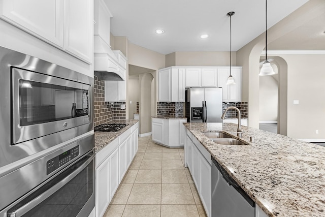 5622 Chipstone Trail Ln, Katy, TX 77493 - kitchen featuring arched walkways, stainless steel appliances, backsplash, white cabinets, and ornamental molding
