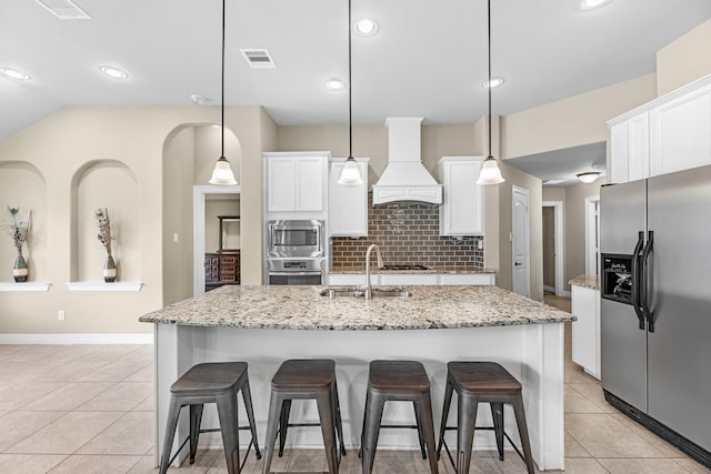 5622 Chipstone Trail Ln, Katy, TX 77493 - kitchen with stainless steel appliances, premium range hood, a breakfast bar area, light tile patterned floors, and tasteful backsplash