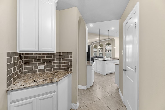 5622 Chipstone Trail Ln, Katy, TX 77493 - kitchen with white cabinets, light tile patterned floors, backsplash, stone counters, and recessed lighting