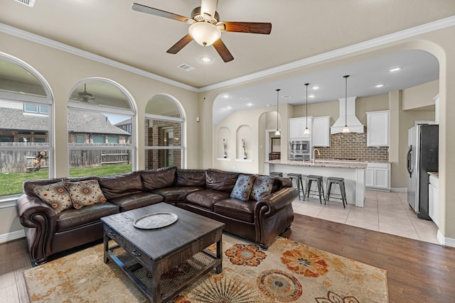 5622 Chipstone Trail Ln, Katy, TX 77493 - living room featuring ceiling fan, light wood-style floors, ornamental molding, arched walkways, and recessed lighting