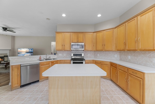 15215 Millers Run Ln, Sugar Land, TX 77498 - kitchen featuring appliances with stainless steel finishes, a peninsula, a ceiling fan, light tile patterned flooring, and light countertops