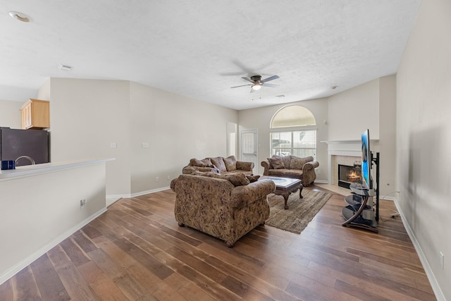 15215 Millers Run Ln, Sugar Land, TX 77498 - living room with ceiling fan, wood finished floors, a tile fireplace, and a textured ceiling