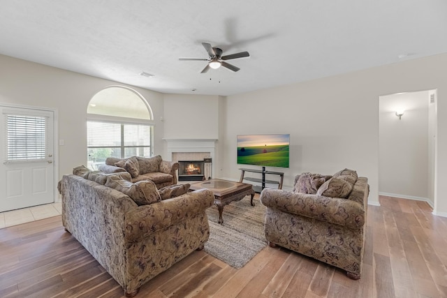15215 Millers Run Ln, Sugar Land, TX 77498 - living area featuring ceiling fan, hardwood / wood-style floors, and a warm lit fireplace