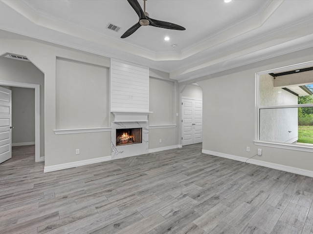 14606 Half Circle St, Splendora, TX 77372 - unfurnished living room with a raised ceiling, ornamental molding, a ceiling fan, a high end fireplace, and wood finished floors