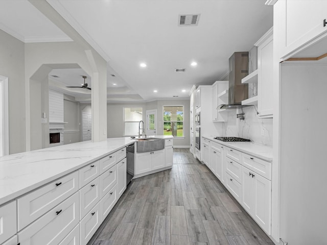 14606 Half Circle St, Splendora, TX 77372 - kitchen with wall chimney exhaust hood, a ceiling fan, recessed lighting, appliances with stainless steel finishes, and white cabinetry