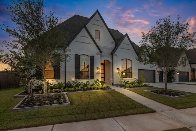 6826 Mirabeau Ln, Katy, TX 77493 - french country style house with concrete driveway, an attached garage, brick siding, and roof with shingles
