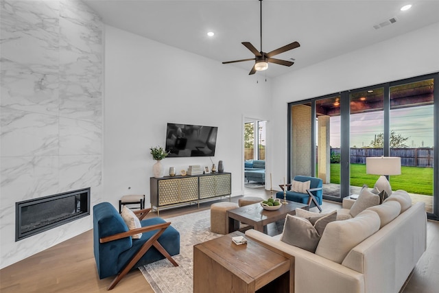 6826 Mirabeau Ln, Katy, TX 77493 - living room featuring a premium fireplace, wood finished floors, a ceiling fan, and recessed lighting