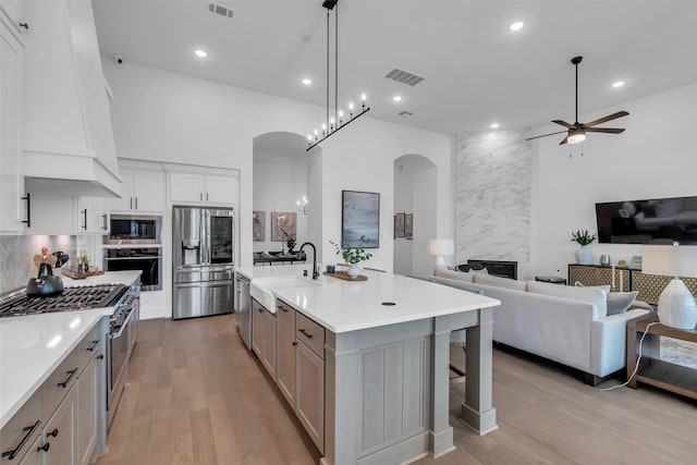 6826 Mirabeau Ln, Katy, TX 77493 - kitchen with appliances with stainless steel finishes, arched walkways, a ceiling fan, light wood-type flooring, and recessed lighting
