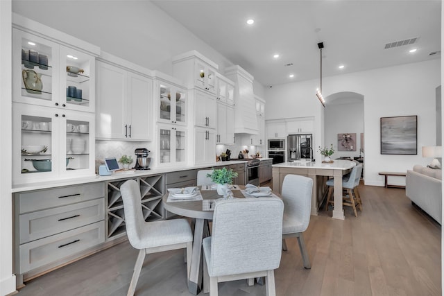 6826 Mirabeau Ln, Katy, TX 77493 - dining area featuring arched walkways, wood finished floors, recessed lighting, and built in desk
