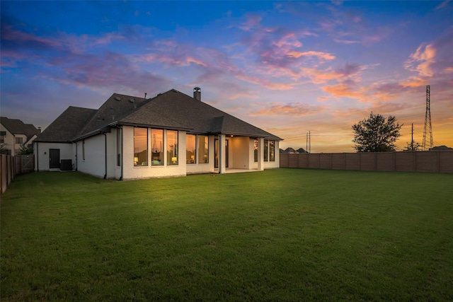6826 Mirabeau Ln, Katy, TX 77493 - back of house at dusk with a fenced backyard and a shingled roof