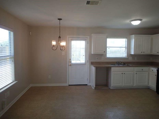 6906 Lost Timber Ln, Richmond, TX 77469 - kitchen with a chandelier, white cabinets, and hanging light fixtures