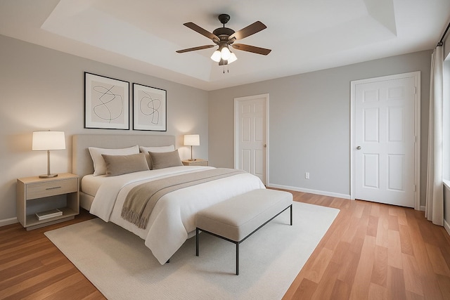 10834 Glenora Dr, Houston, TX 77065 - bedroom featuring a tray ceiling and light wood-style flooring