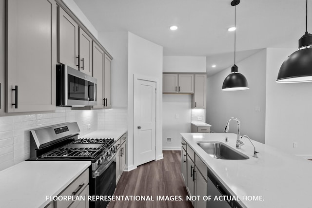 26112 Ethereal Rd, La Marque, TX 77563 - kitchen featuring appliances with stainless steel finishes, gray cabinetry, dark wood-style floors, light countertops, and backsplash